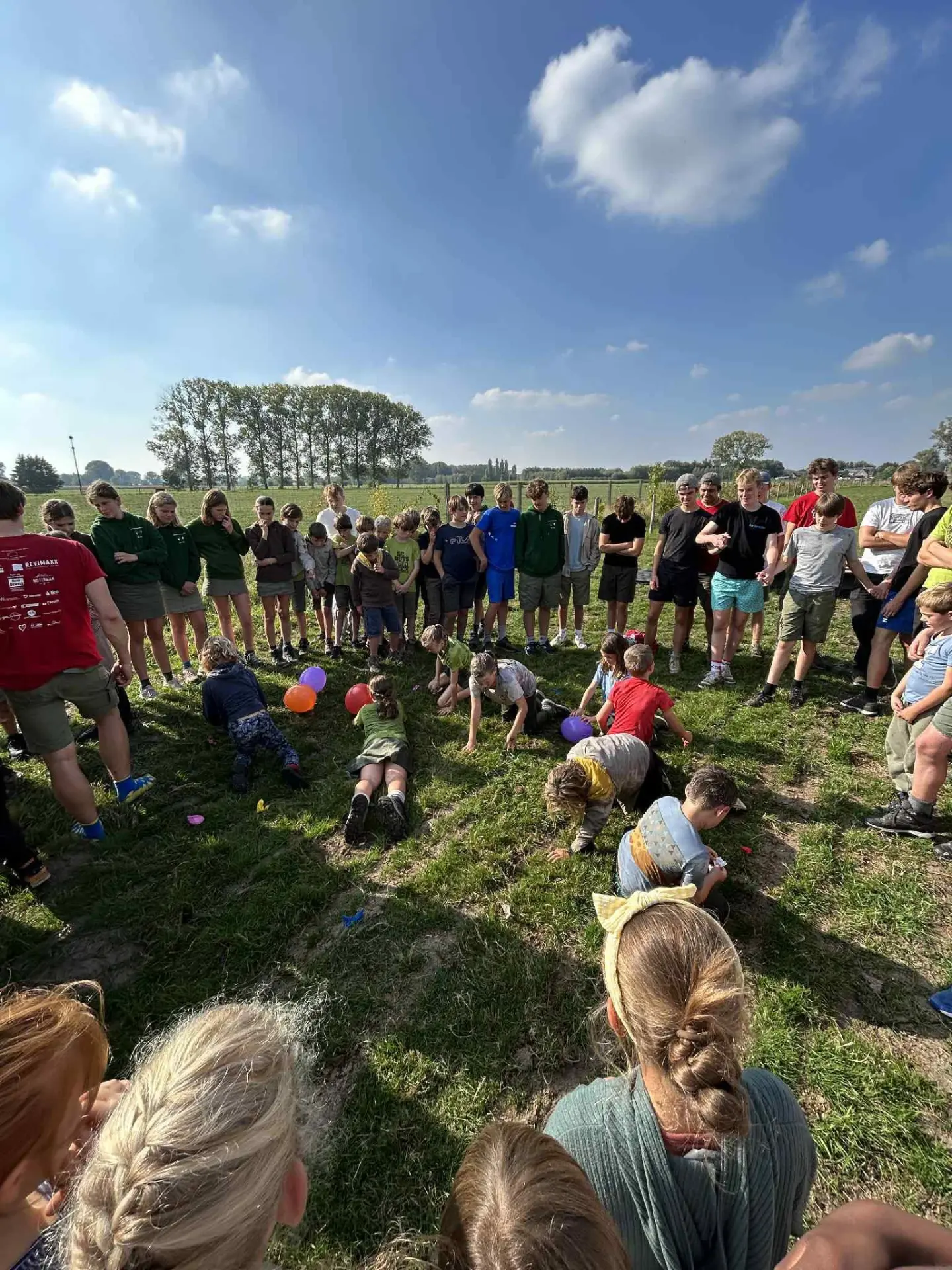 Spel in een kring met alle takken samen tijdens het overgangsweekend