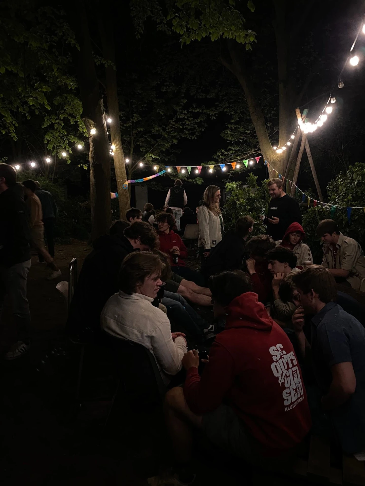 Bezoekers rond het kampvuur tijdens het scoutscafé